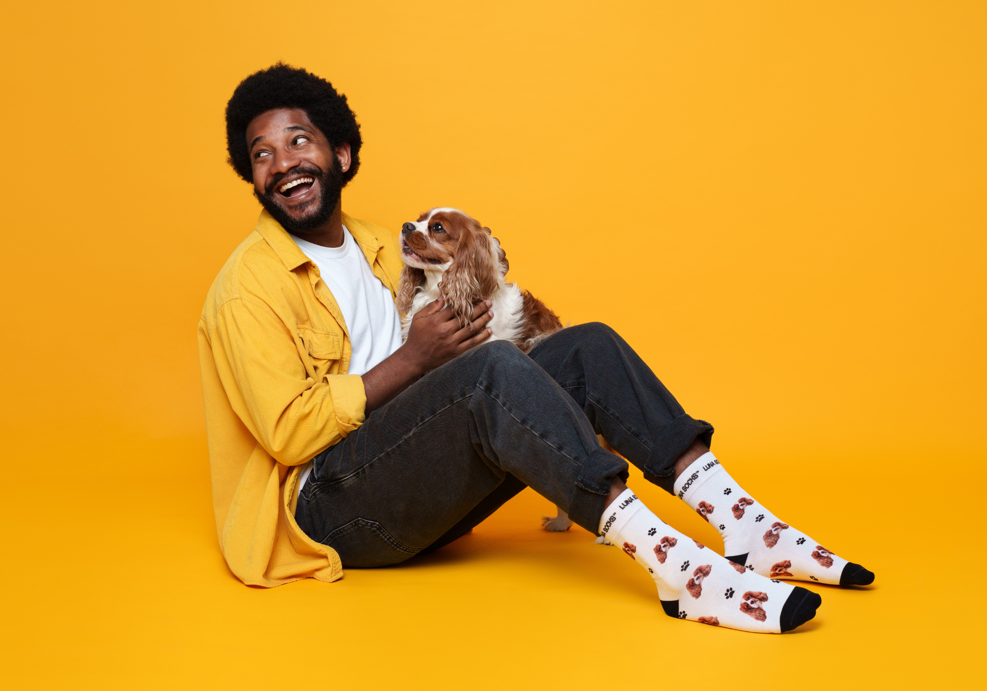 Guy cuddling a dog with custom pet socks